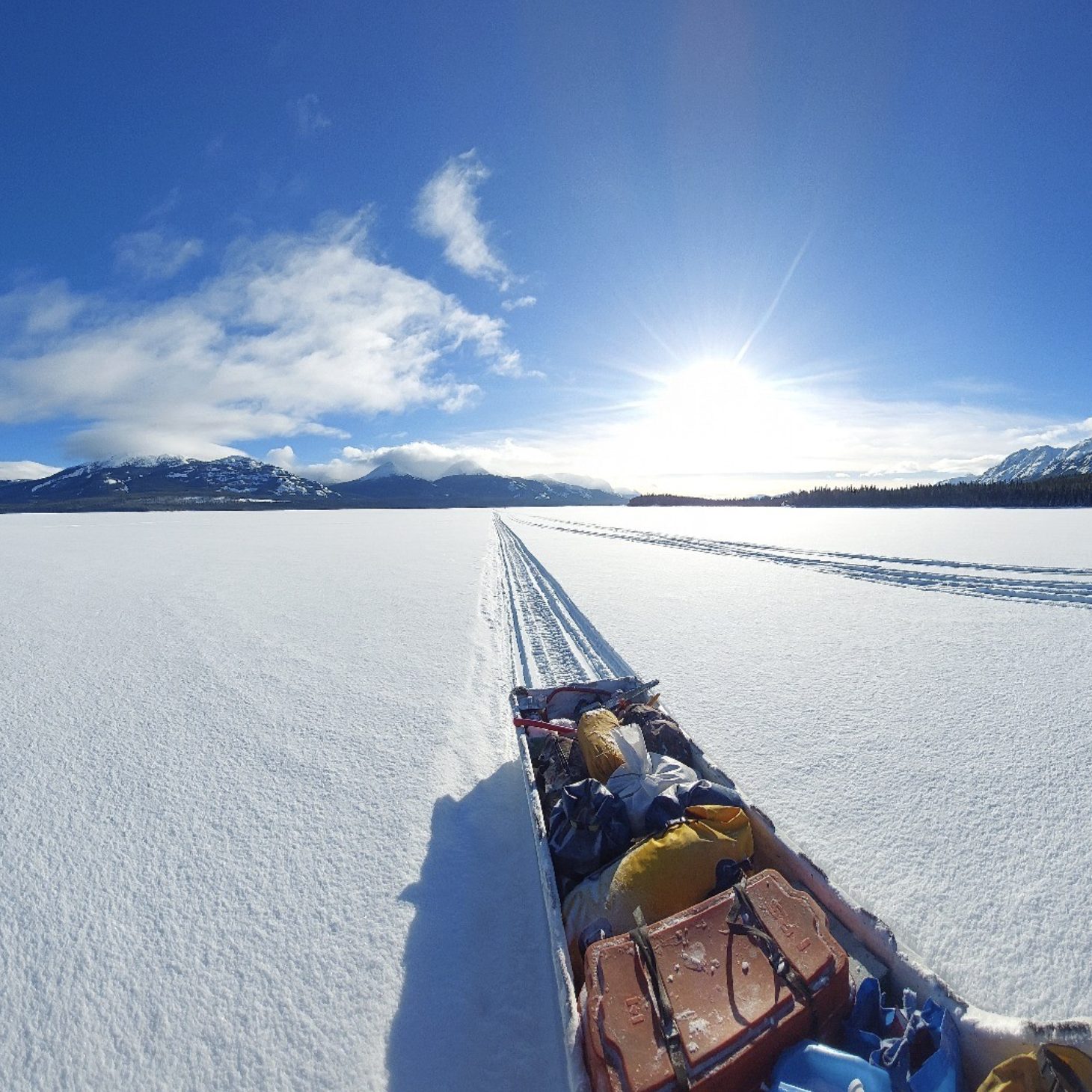Loaded expedition sled on a frozen lake in bright sunshine, Yukon