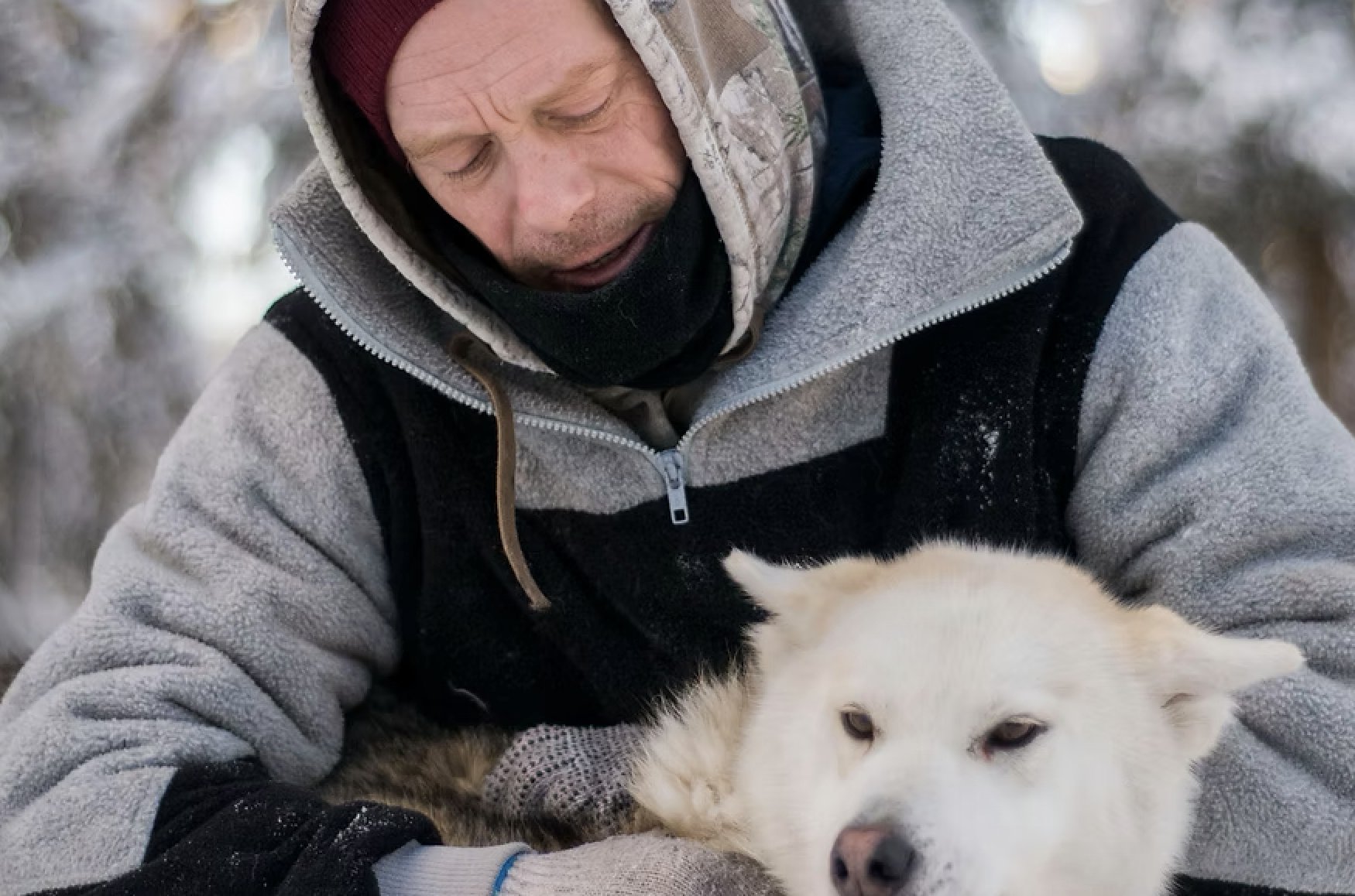 Bertrand holding one of his white huskies