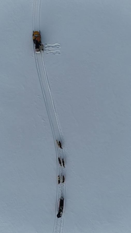 Vue aérienne d'un attelage et d'une motoneige sur un lac gelé